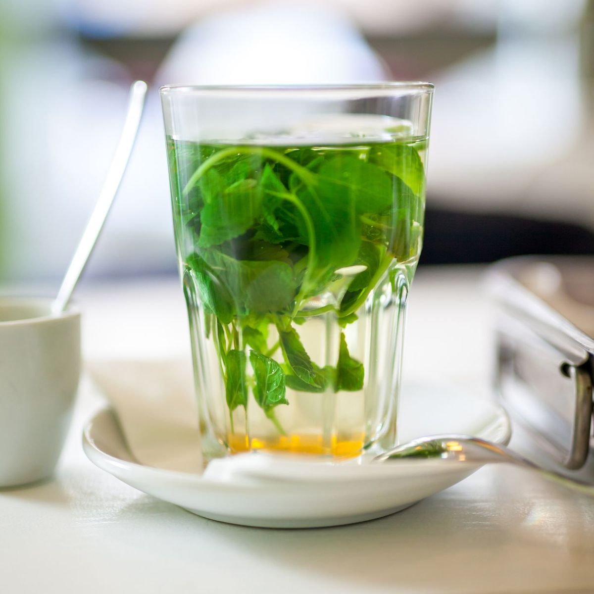 Vaso de té de menta verde con hojas de remojo