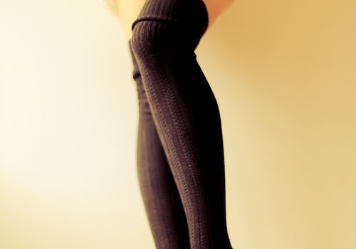 אישה עומדת על כן עם גרביים שחורות בגובה הירך