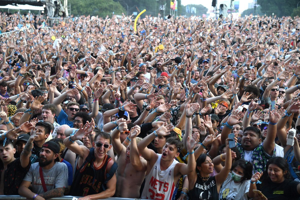 Hunderte Fans heben die Hände in die Luft und singen während eines Nachmittags beim Lollapalooza-Musikfestival.