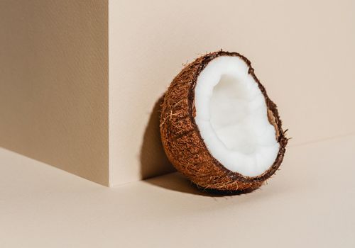 Kokosnuss gegen braune Wand und Hintergrund