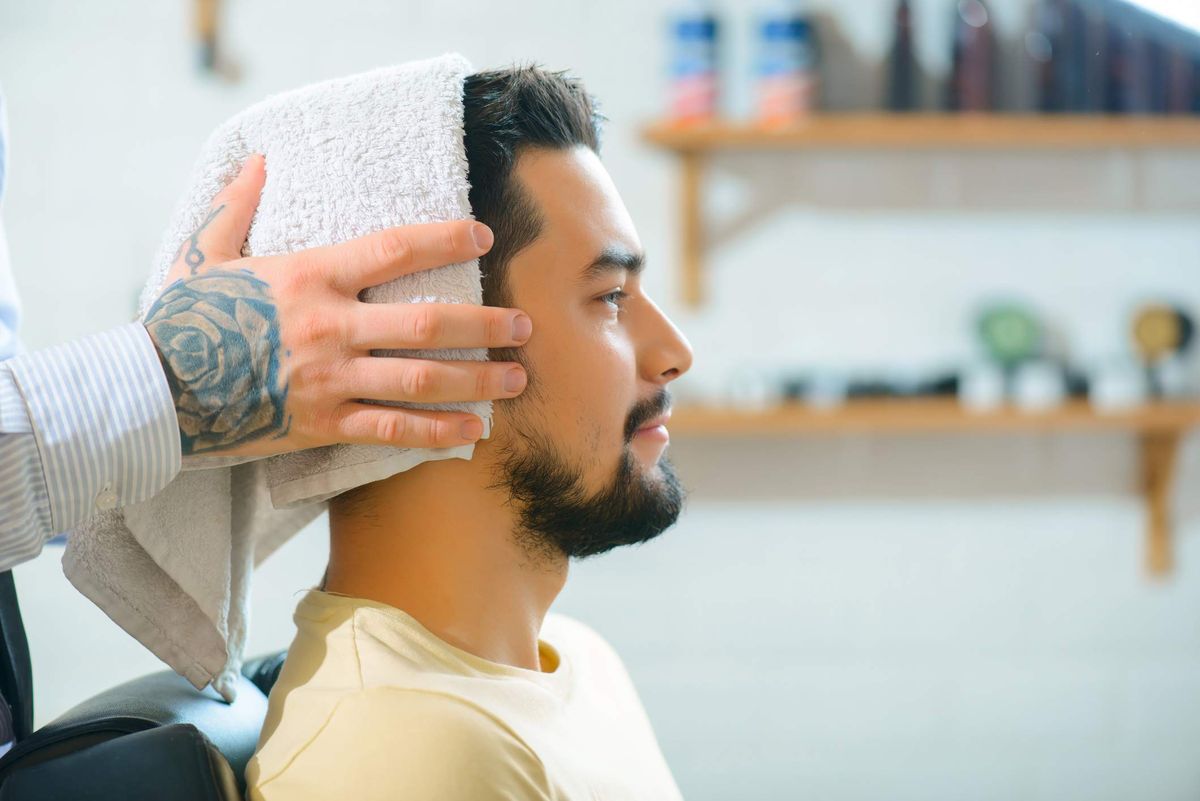 čovjek se suši ručnikom za kosu