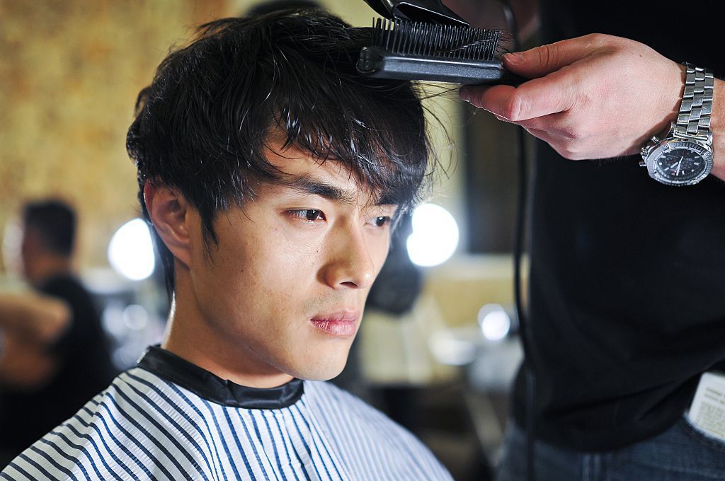 Homem asiático cortando o cabelo