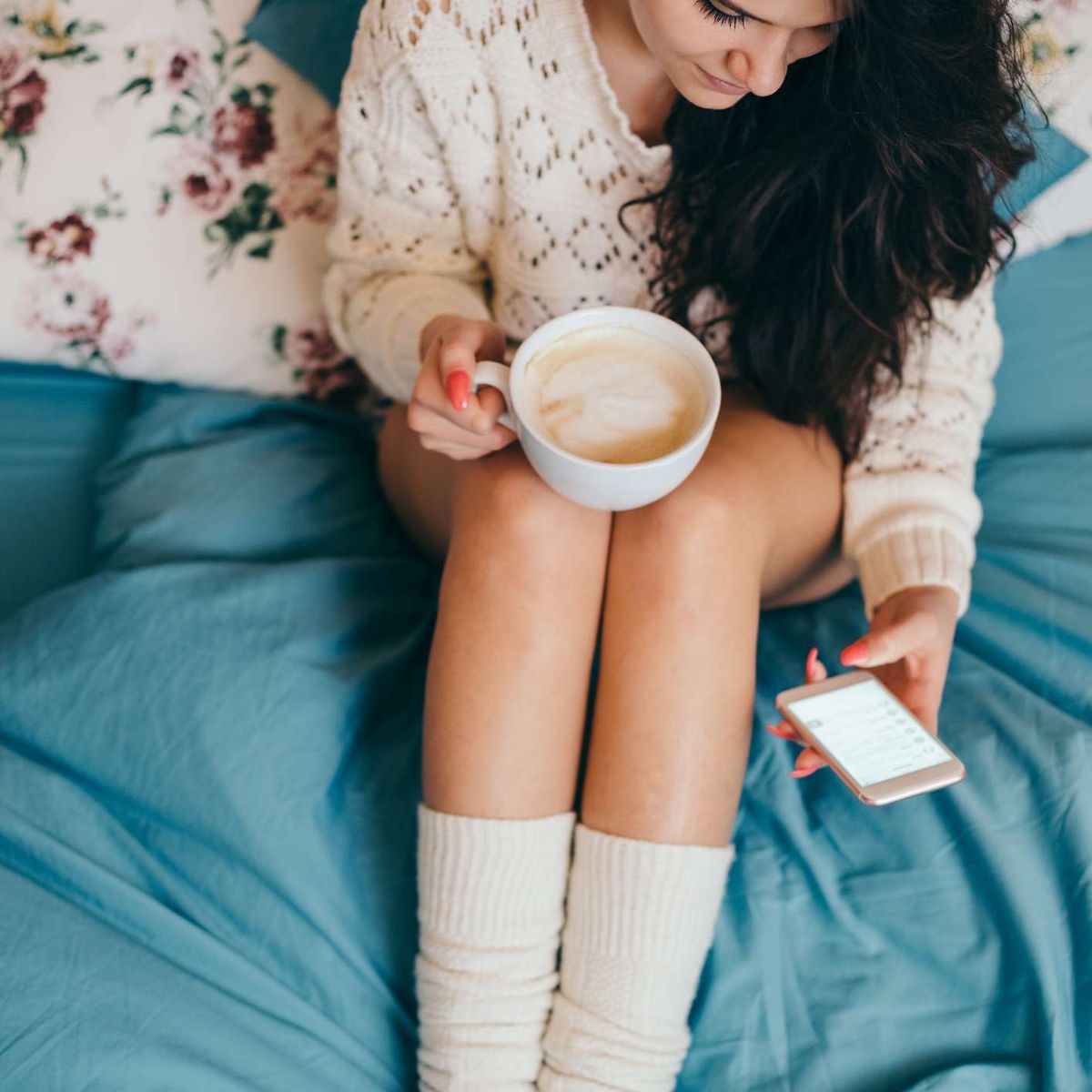 kvinde i sengen med kaffe og sokker