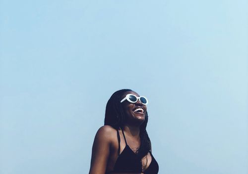 Frau im schwarzen Badeanzug gegen blauen Himmel