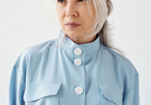Frau mit weißen Haaren, die ein blaues Hemd tragen