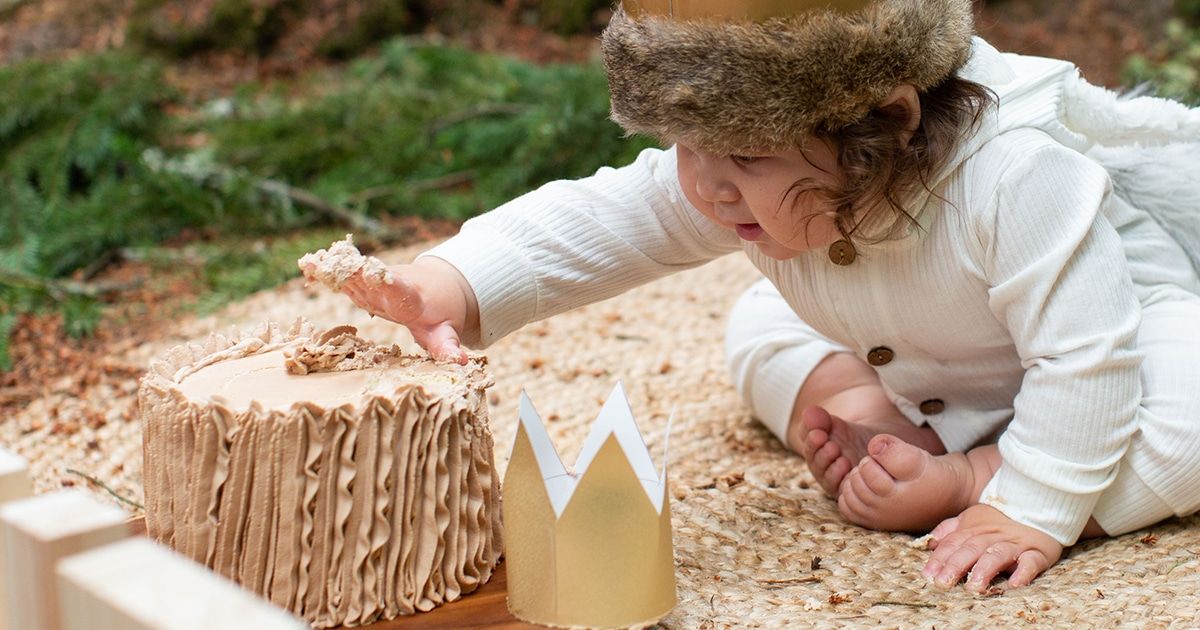ילד בן שנה מושיט יד לעבר עוגה מרוסקת