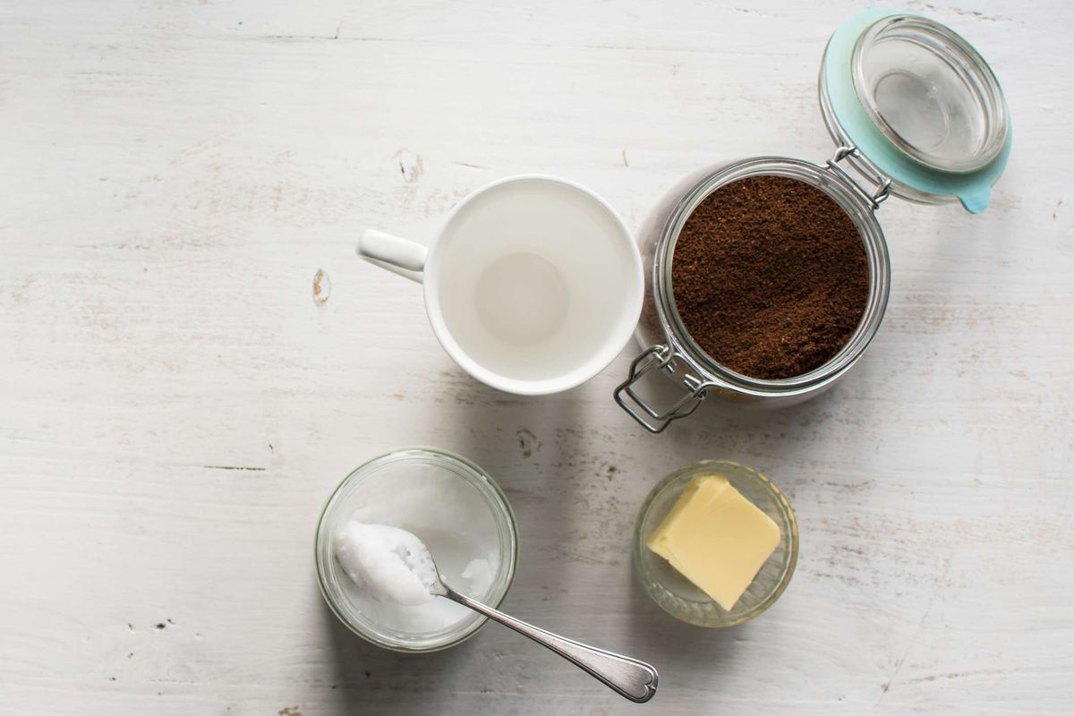 ingredienser til skudsikker kaffe (krus, smør, MCT-olie og kaffegrums) på et bord.