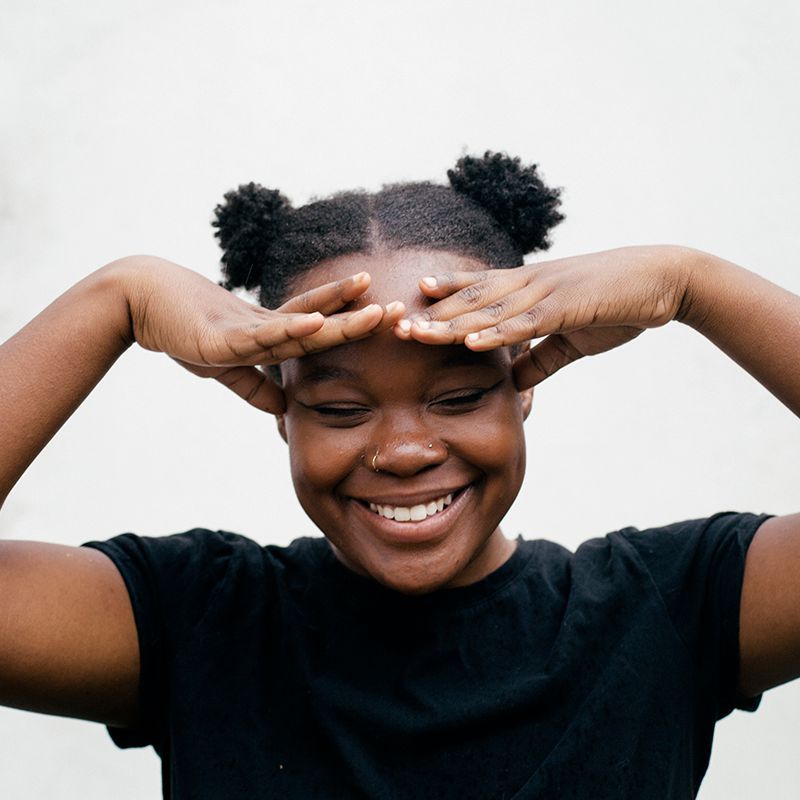 jauna juodaodė mergina su afro šypsena