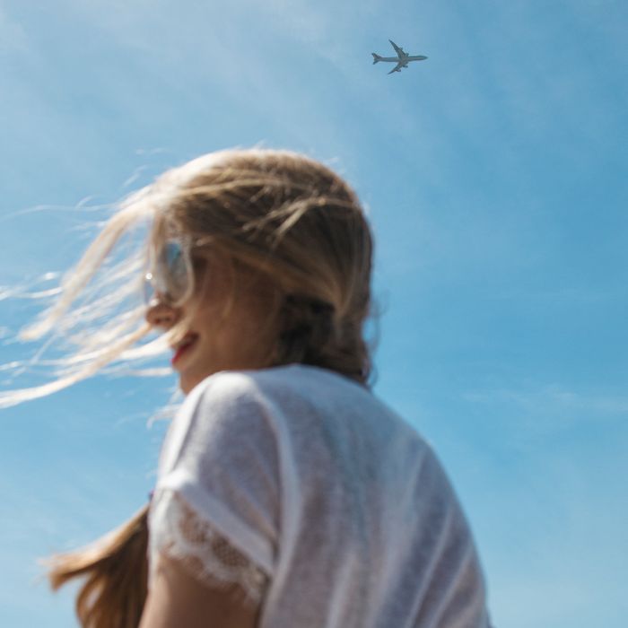 기내 장거리 스킨 케어 루틴 : 비행기 아래 서있는 여성