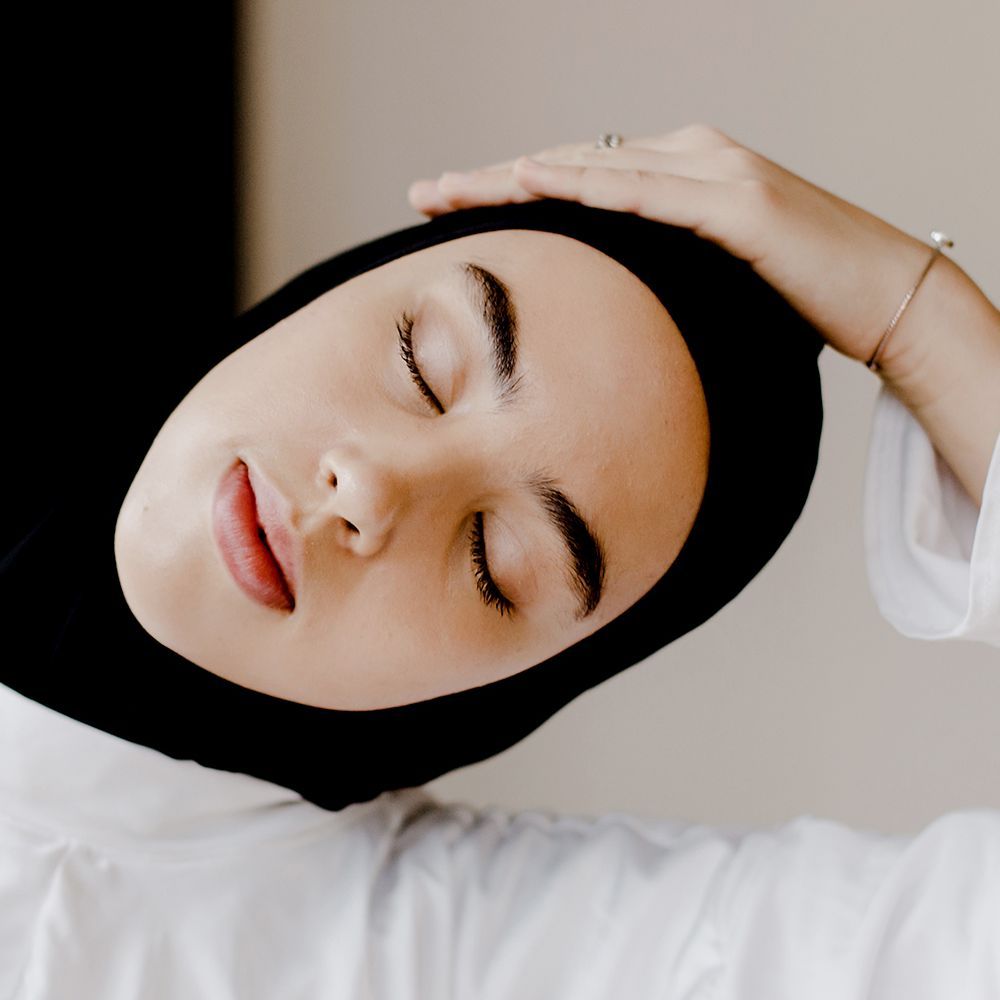muslimische Femme, die den Hals streckt