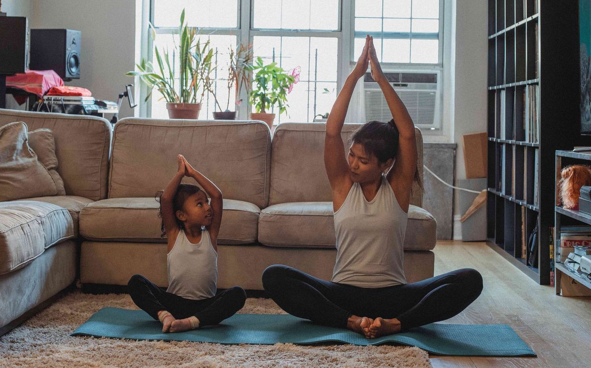 Mãe e filha fazendo ioga em casa