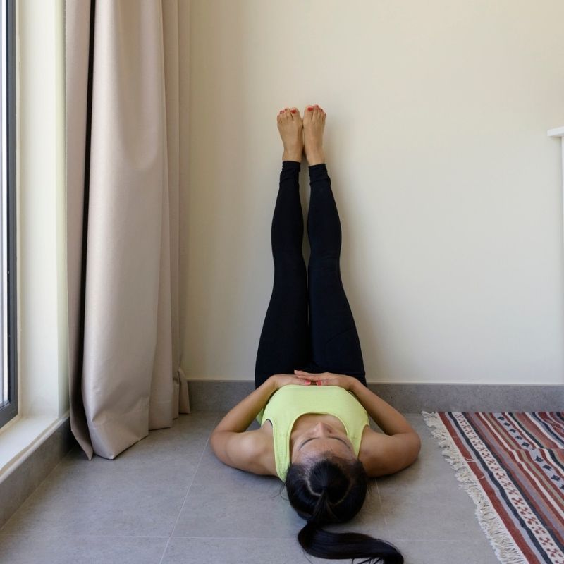 mujer practicando piernas arriba de la pared pose