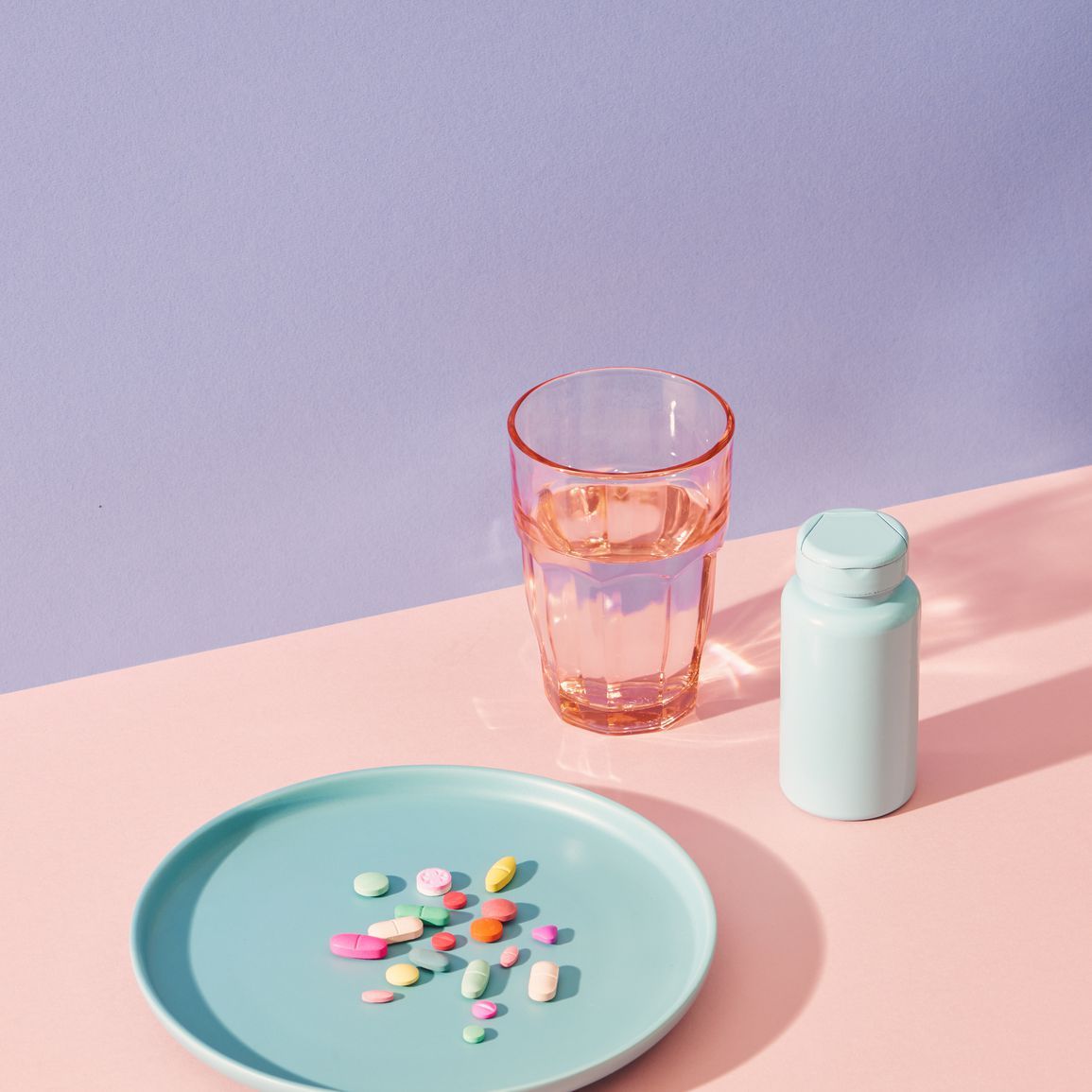 Vitaminpräparate auf dem Tisch mit Glas und Tablettenfläschchen