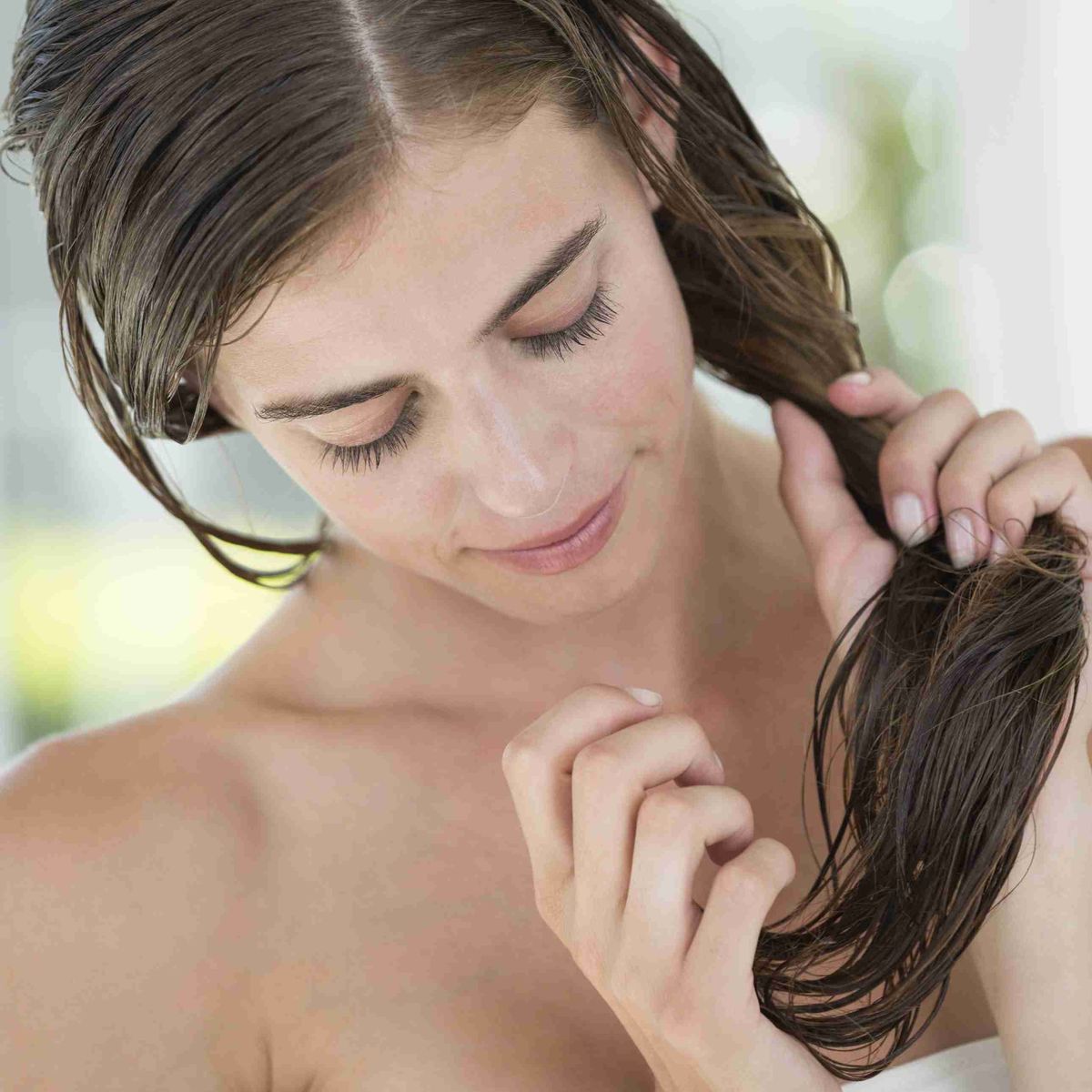 mujer aplicando acondicionador en el cabello