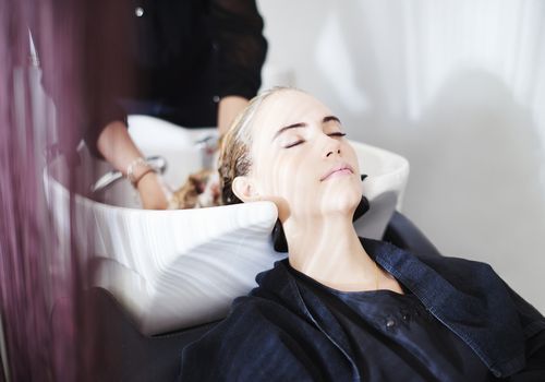 Kvinde får hår vasket i en salon