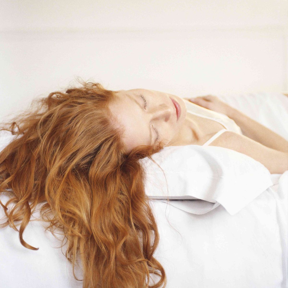 rødhåret kvinde liggende på en seng