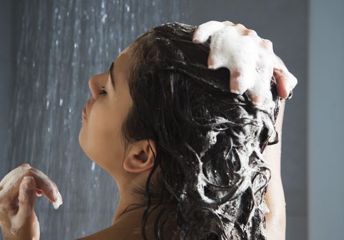 En ung kvinde, der vasker håret