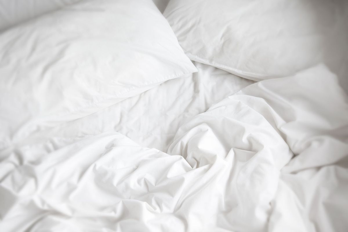 weiße Bettwäsche, Kissen und Bettdecke.