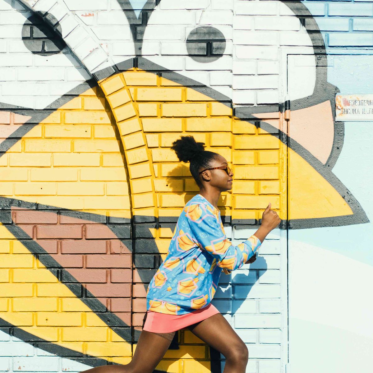 nainen juoksee maalattua seinää vasten