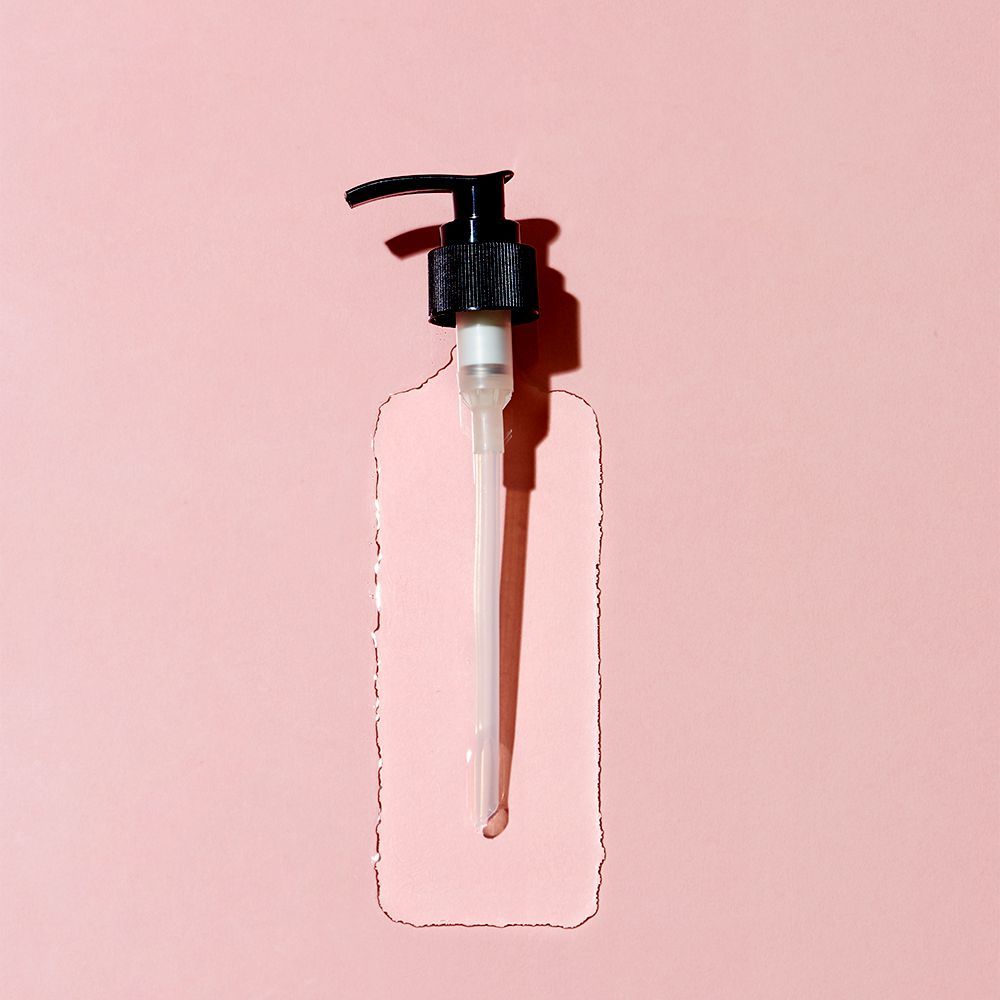 dekonstrueret shampoo flaske på lyserød baggrund