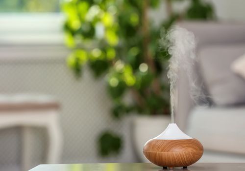Aroma olejový difuzér na stole proti rozostrenému pozadiu