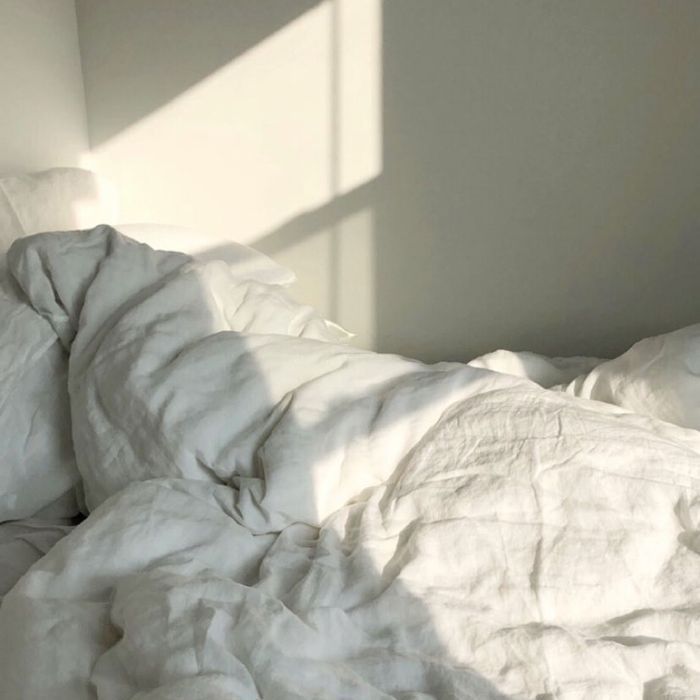 Person versteckt unter einer Bettdecke im Bett