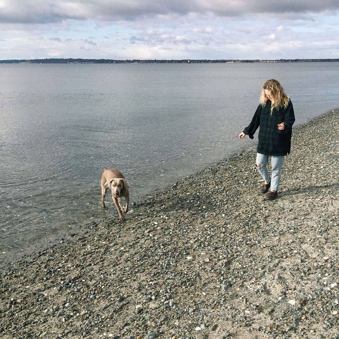 강아지와 함께 해안선을 따라 걷는 여자