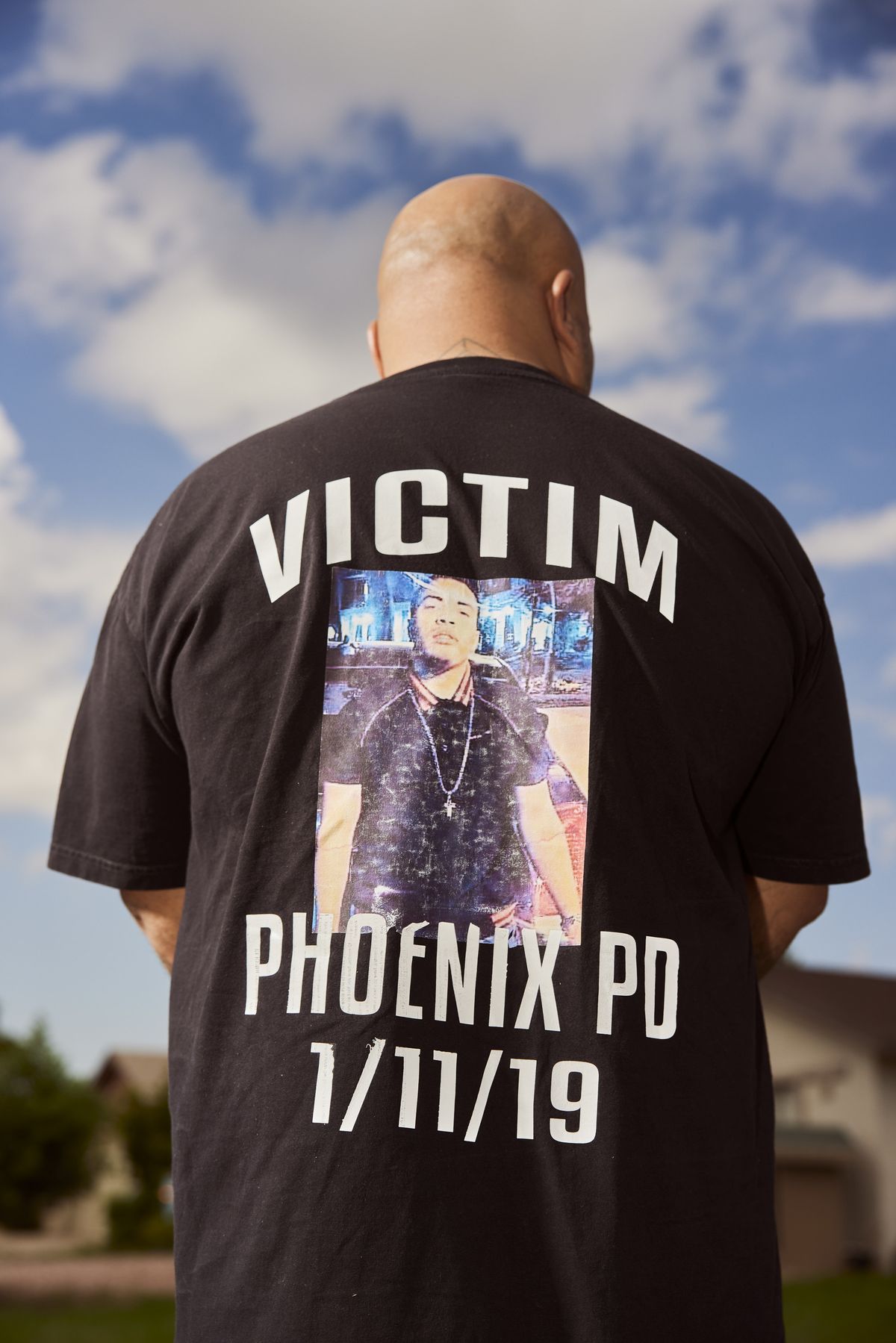 Roland fotografiado desde atrás, su camiseta dice Victim Phoenix PD 1/11/19, con una fotografía de Jacob.