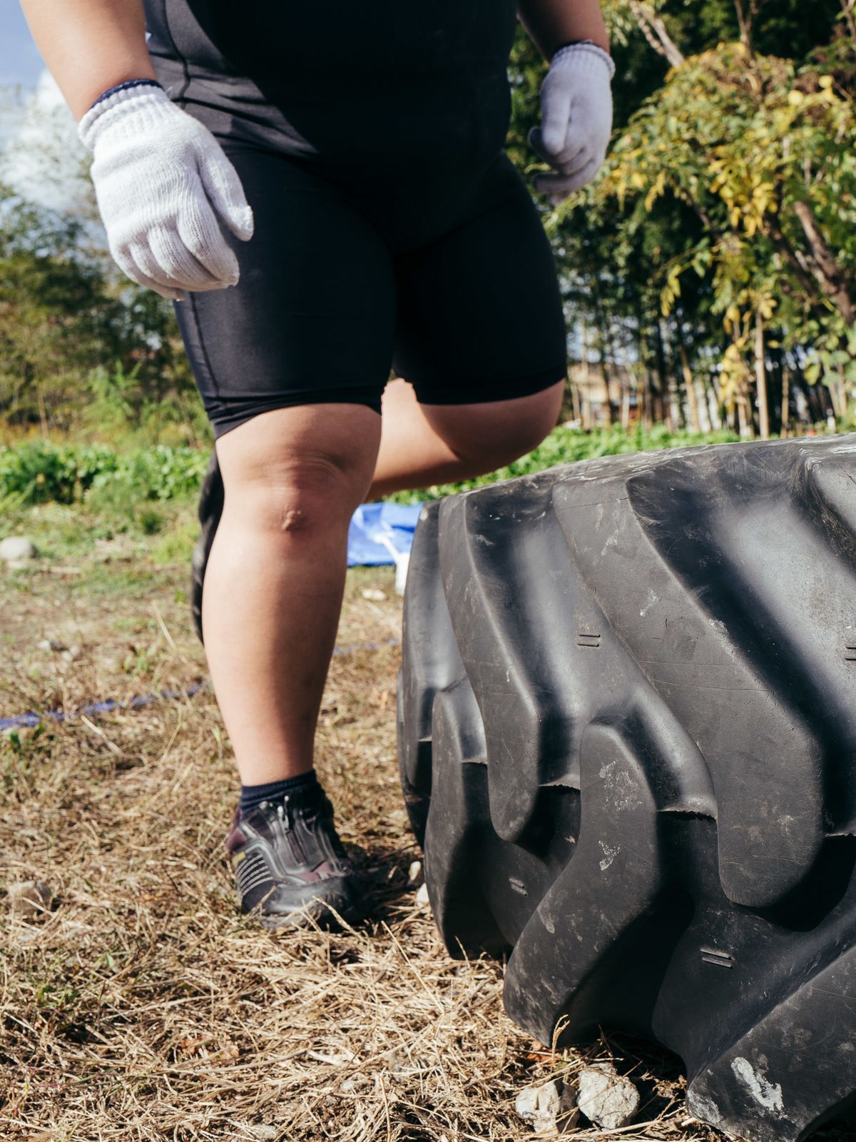 Eine junge Sumoringer wirft Reifen in ihrem Hinterhof um