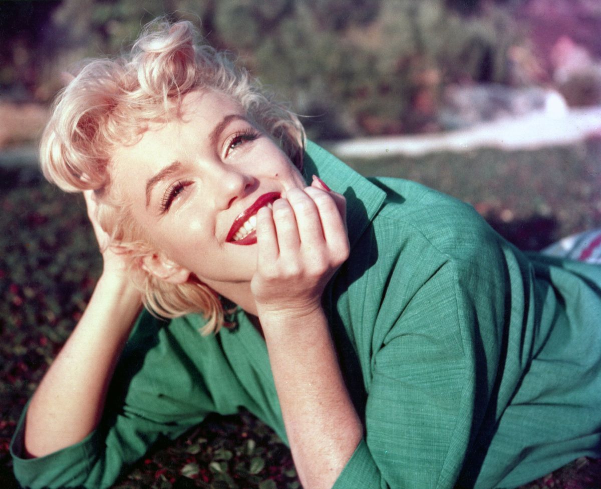 Marilyn Monroe liegt im Anzug im Gras