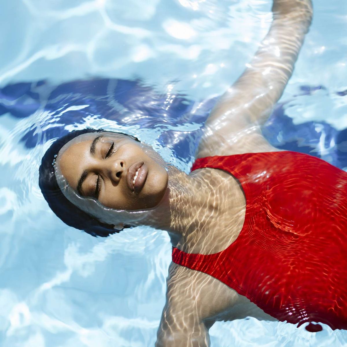 אישה שחורה חובשת כובע שחייה בבריכה