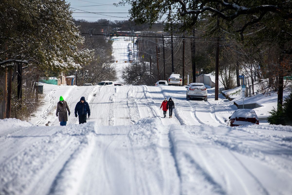 Zwei Paare von Menschen, die in Texas extrem verschneite Straßen entlang gehen