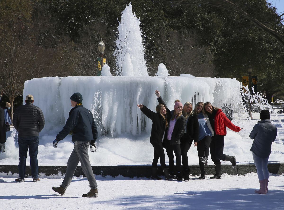 Eine Gruppe junger Frauen posiert gemeinsam für ein Foto vor einem zugefrorenen Brunnen