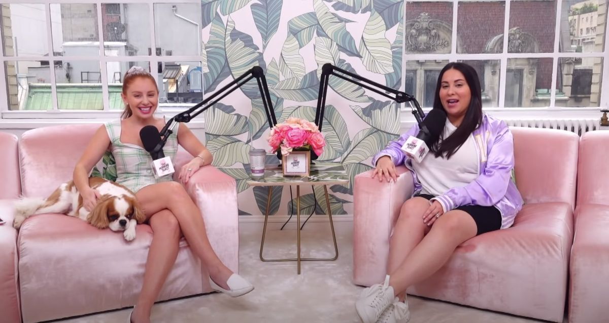 Jackie en Claudia, zittend op pluche millennial roze banken, nemen hun podcast op