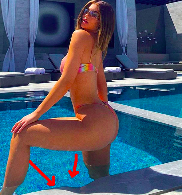 Kylie Jenner trägt einen Bikini und steht mit einem gebeugten Bein in einem Pool nebenan