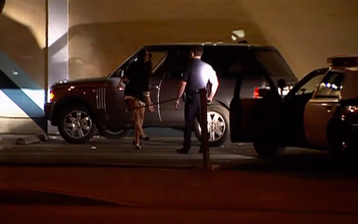 Kuvakaappauksessa Khloé kävelee linjassa raittiustestin aikana autonsa ulkopuolella poliisin kanssa