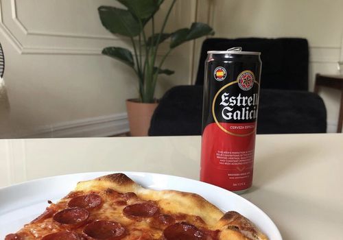 Pizza und ein Bier auf einem Tisch