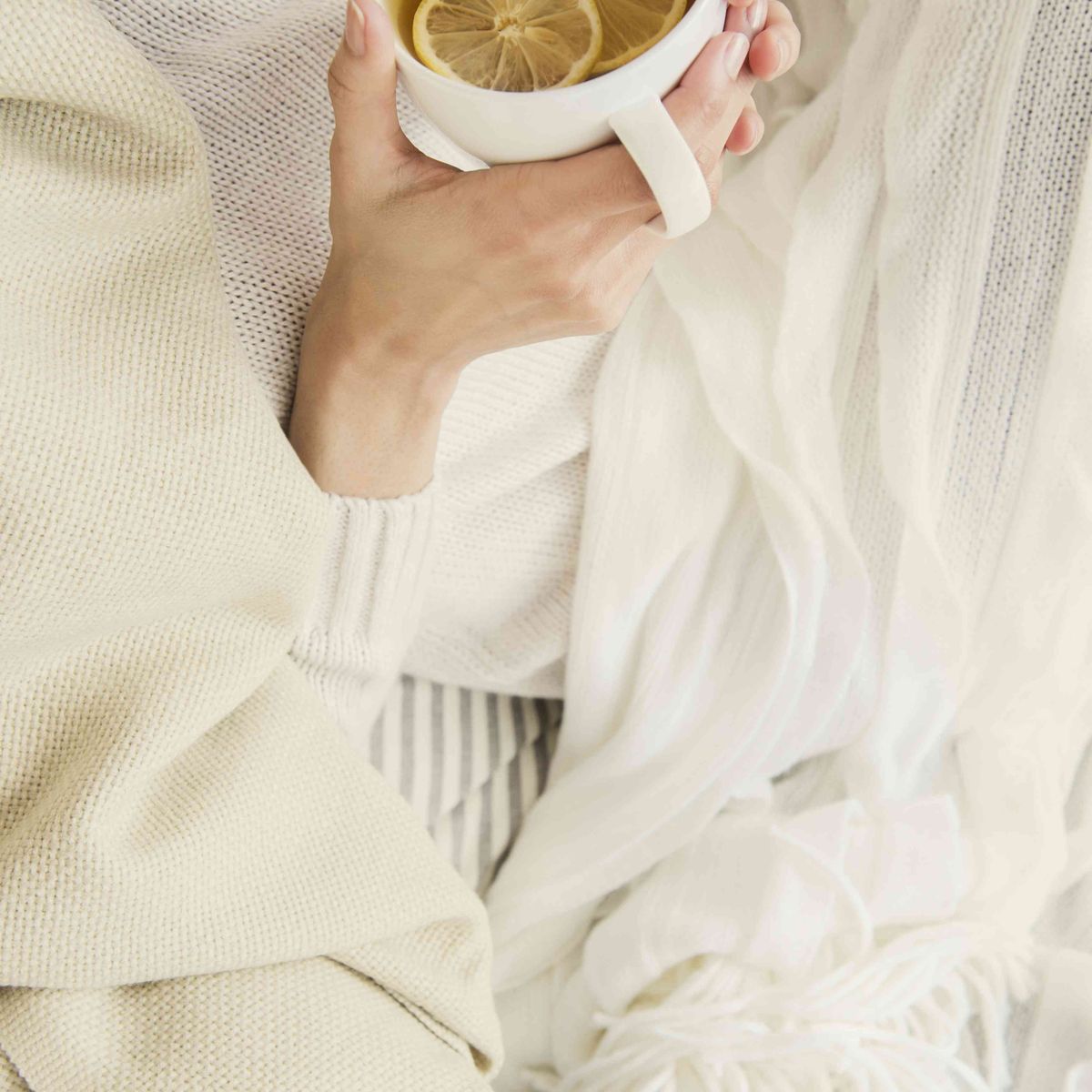 Sort kvinde, der drikker kop te med citron