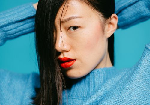 asiatisk femme i blå sweater