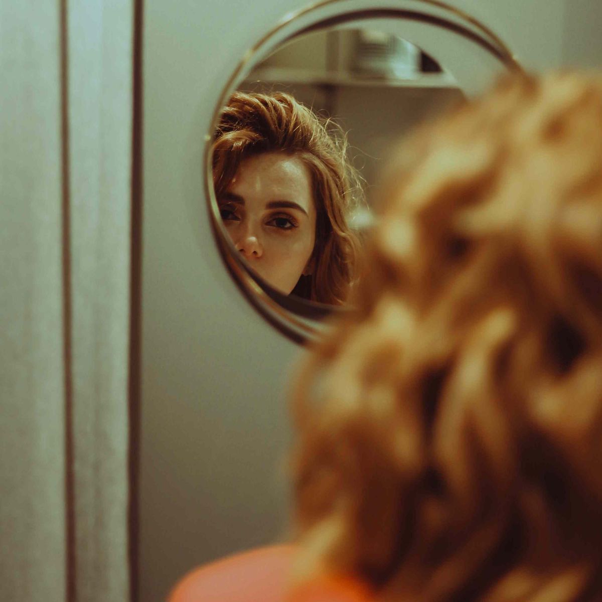 Frau, die Haut im Spiegel betrachtet