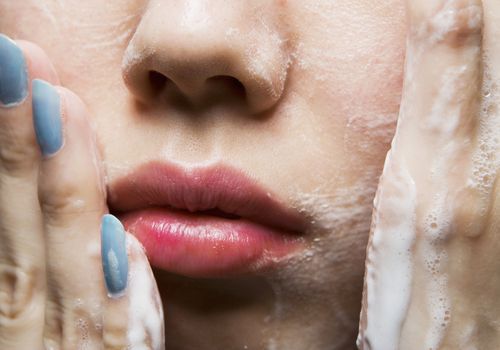 Kvinde vasker ansigt efter hudlæge