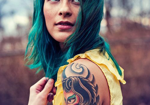 Mergina su mėlynais plaukais ir tatuiruotėmis