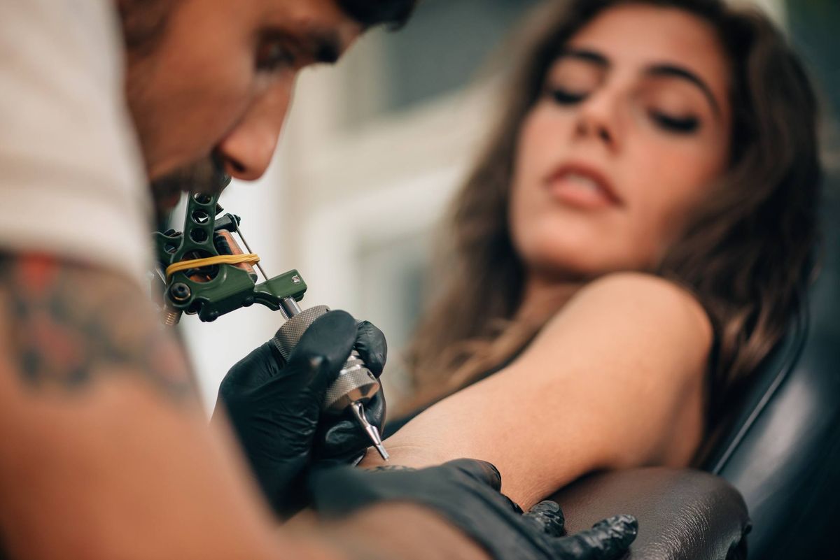 Vyras tatuiruoja moterį