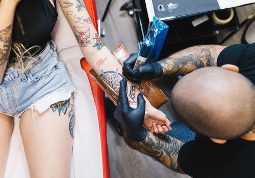 Mulher fazendo uma tatuagem