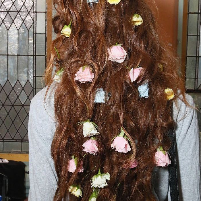 Modèle Rodarte avec des roses multicolores éparpillées dans ses cheveux à NYFW