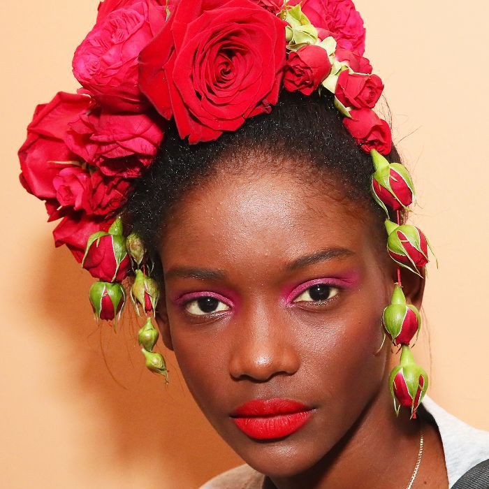 Modèle Rodarte avec des roses rouges surdimensionnées dans ses cheveux à NYFW