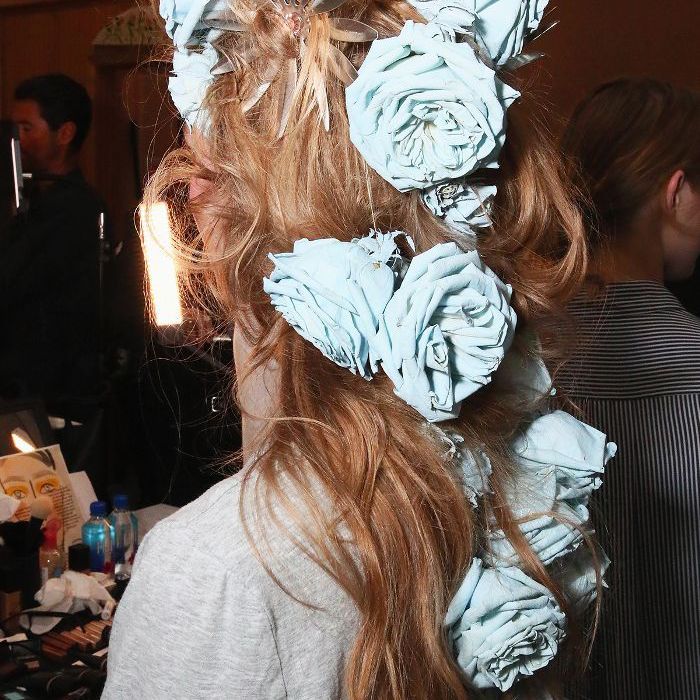 Modèle Rodarte avec des roses bleues surdimensionnées dans ses cheveux à NYFW
