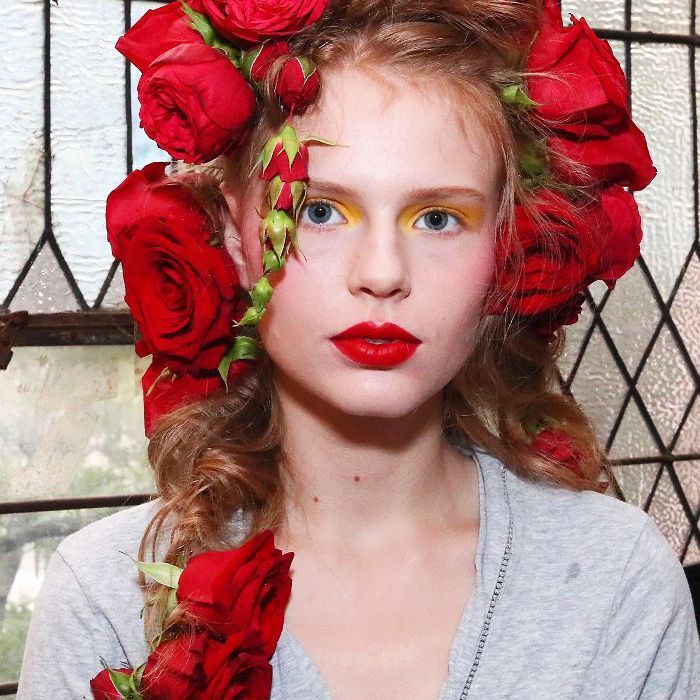 Modèle Rodarte avec des roses rouges surdimensionnées dans ses cheveux à NYFW