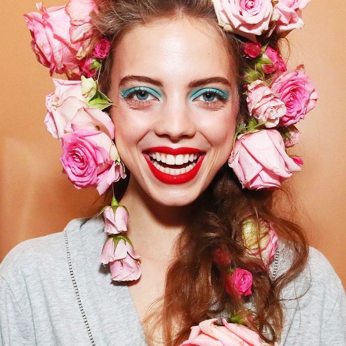 Modèle Rodarte avec des roses roses surdimensionnées coiffées dans ses cheveux à la NYFW